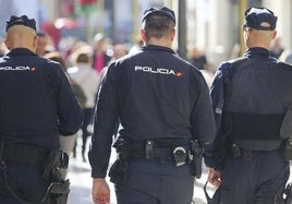 Tres policías nacionales patruyando por la calle.