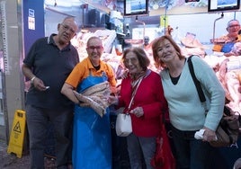 Tres clientes sonrientes junto a Maica Santana, encargada del puesto de la pescadería Hnos. Montesdeoca del Mercado Central.