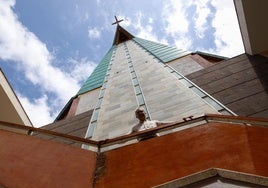Alejandro García se sitúa bajo el emblema de esta iglesia, su cubierta en forma de ave o paloma, vista desde abajo.