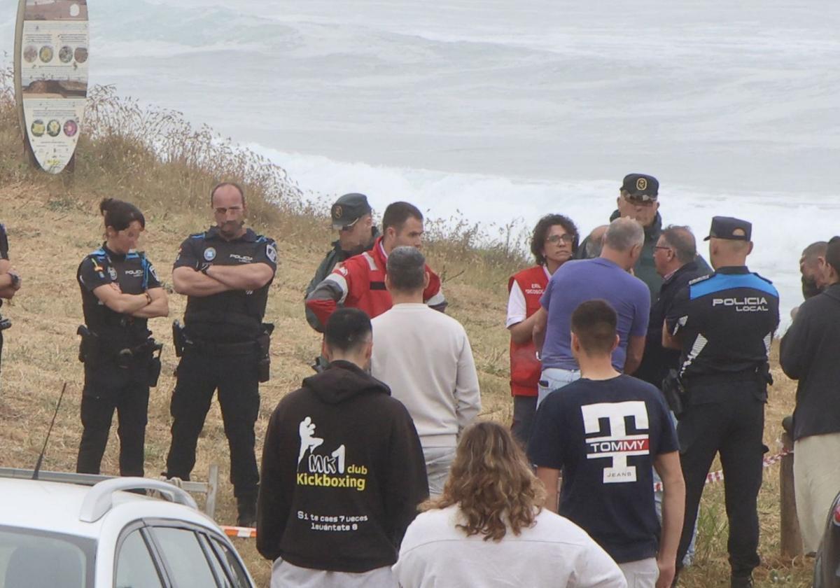 Policía, Guardia Civil y miembros de Cruz Roja, en la playa de Verdicio, atienden a los familiares del pescador fallecido.