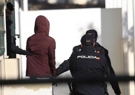 Un agente de policía acompaña a un menor acusado de cometer un delito en Algeciras.