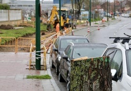 Uno de los árboles talados en la avenida Valle de Aran, al frente, las obras de urbanización de la calle