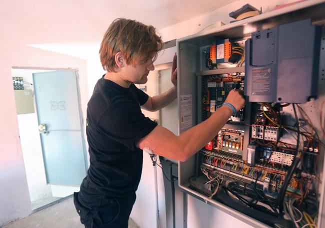 Un técnico de Ascensores de Marco revisa el cuadro eléctrico de un edificio de la calle Huesca de Logroño.