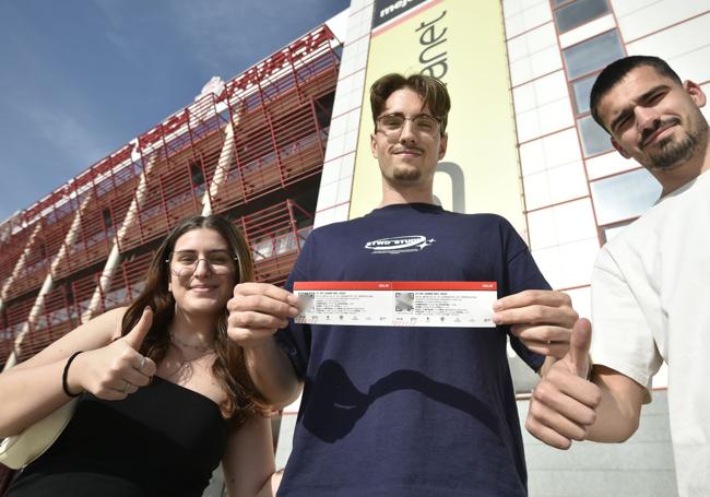 Aficionados muestran sus entradas para el partido del sábado.