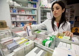 Una farmacéutica dispensa medicamentos.