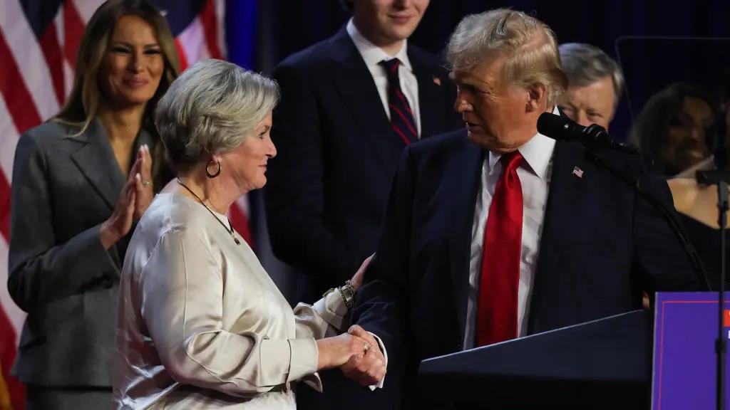 Donald Trump y Susan Wiles se saludan delante de Melania Trump durante la investidura presidencial.